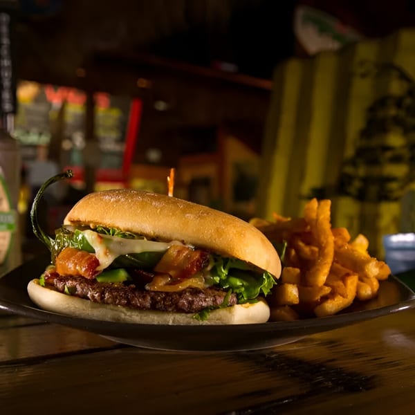 A Wraptitude burger with bacon, cheese, lettuce, and a whole jalapeño, served with fries.